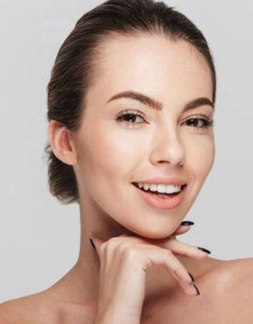 Smiling woman with clear skin resting her chin on her hand